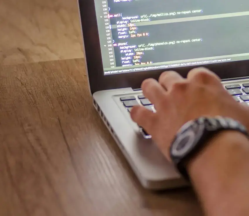 person writing code on a laptop